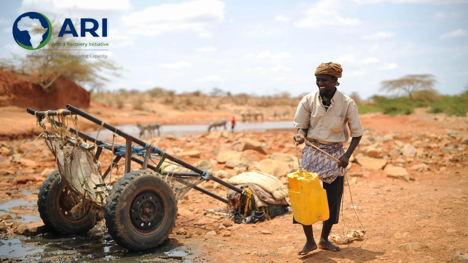 A man draws water from a well in Garbaharey, Gedo region, Somalia, with the Africa Recovery Initiative logo